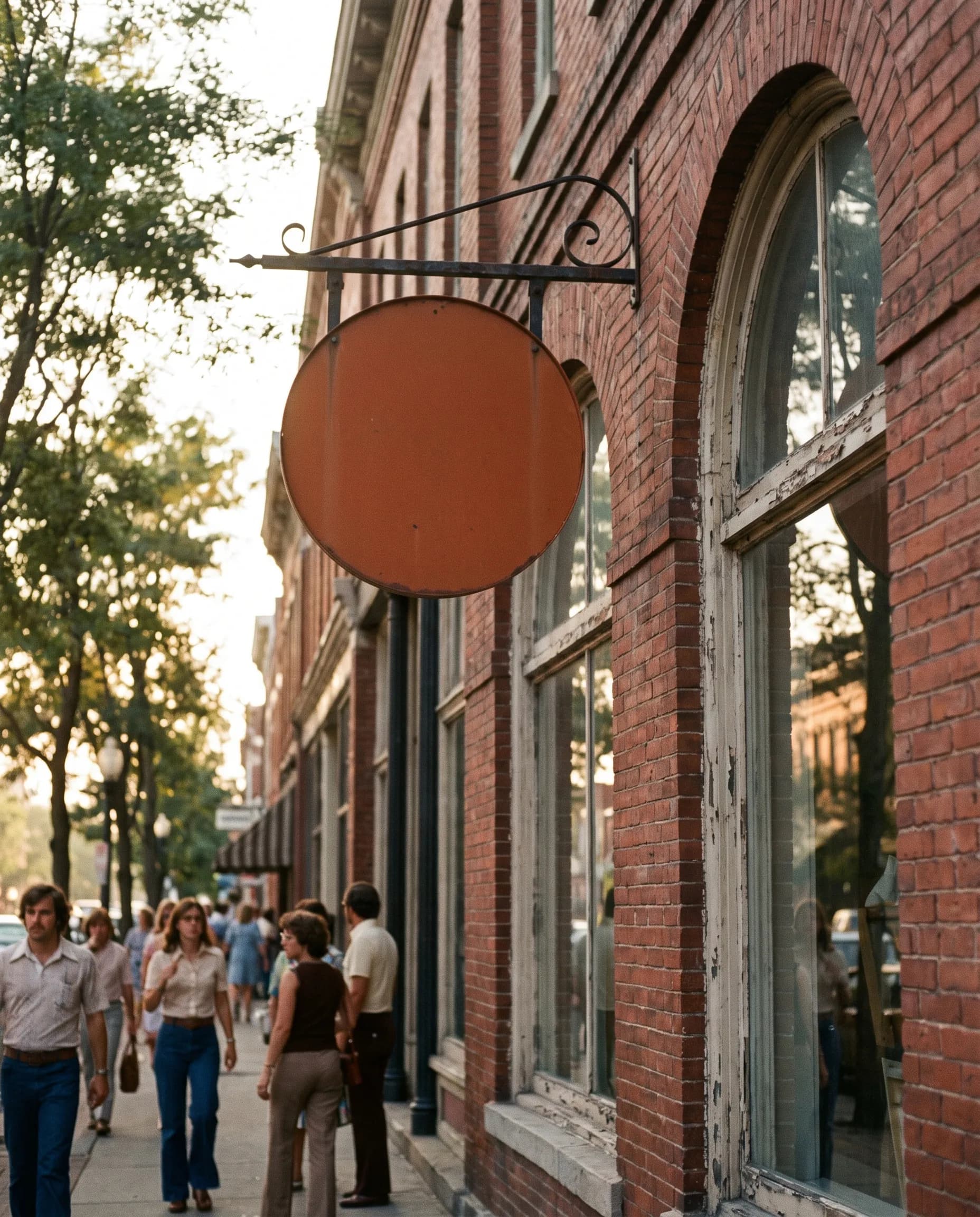Brand identity as a projecting blade sign on an iron bracket at a downtown storefront